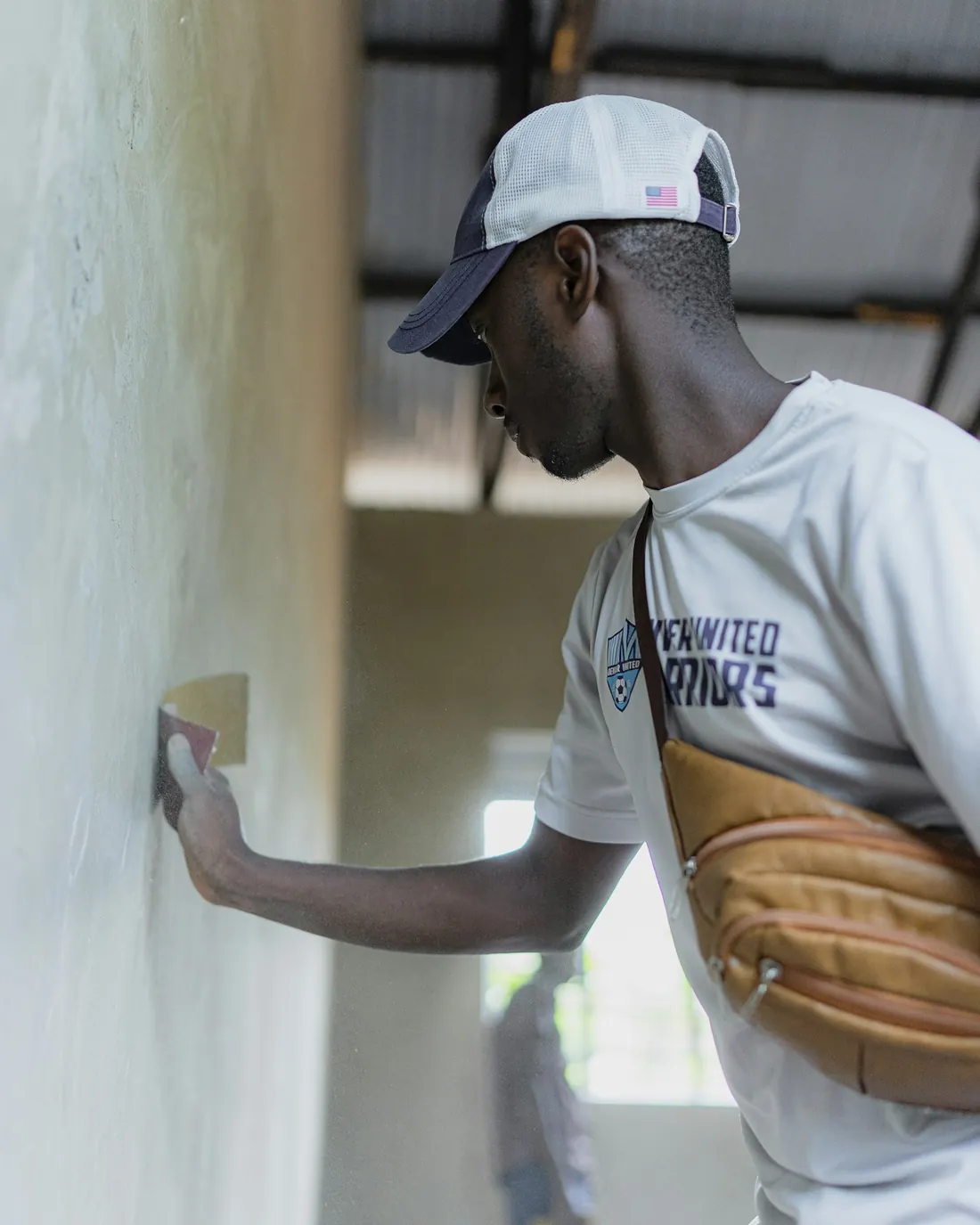 A tradesperson carefully preparing an interior wall
